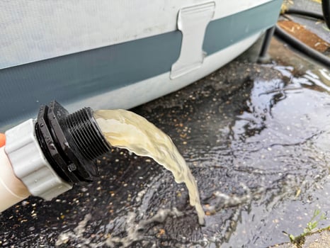 Backwashing the pool water through the sand filter system shows dirty water to clean the filter sand an a pool photo
