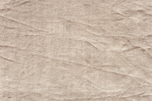 Textured beige fabric with visible wrinkles and folds. The surface soft and natural, suitable for various design applications photo