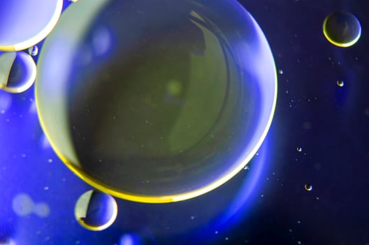 Top view of extreme close up of oil bubbles with gradient light yellow background photo