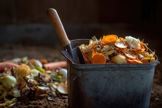 Garden compost bin filled with vegetable scraps and organic material in a rural setting during daytime photo