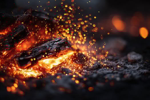 Burning embers and glowing sparks creating a mesmerizing display during a night gathering around a fire pit photo