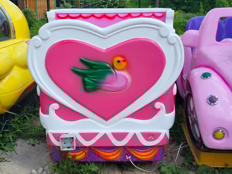 A children's electric car in a children's park with a pink heart and a dove. photo