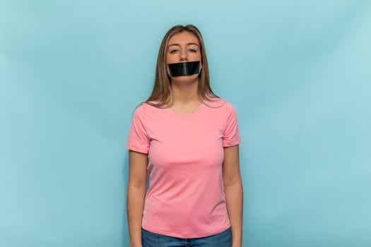Woman wearing pink t-shirt promoting Breast Cancer Awareness with taped mouth photo