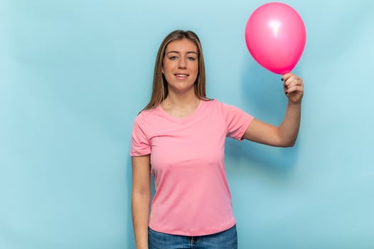 Woman wearing pink t-shirt holding pink balloon for Breast Cancer Awareness photo
