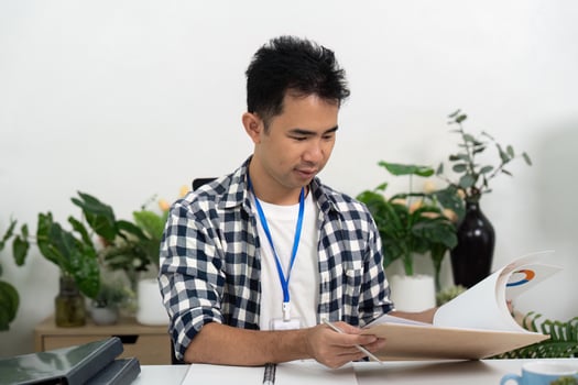 Organization. Young man reviewing documents while seated at a modern desk. photo