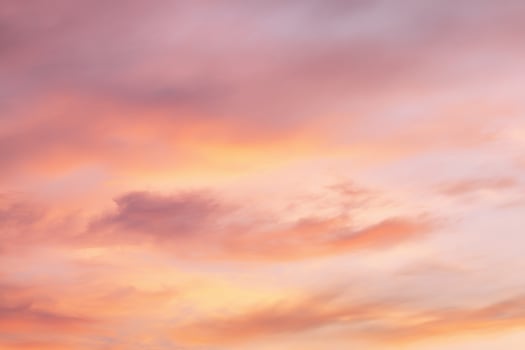 Soft orange and pink clouds stretch across warm sunset sky, evoking calm nature, atmospheric beauty, and dreamy scenic twilight inspiration photo