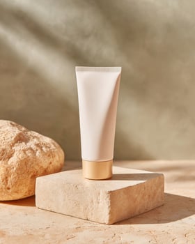 Cosmetic cream tube mockup on stone pedestal in natural light photo