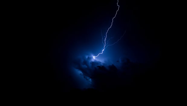 A lightning bolt is seen in the dark sky photo