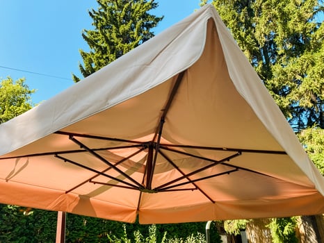 A large, stylish brown umbrella featuring a pristine white roof, perfect for providing shade in outdoor spaces and enhancing the aesthetic of your outdoor furniture setups photo