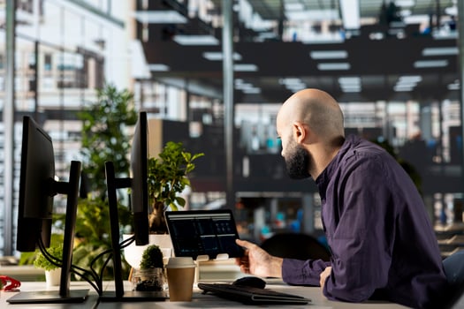 Middle eastern manager in modern office examines infographics to oversee business operations, supporting corporate growth and accomplish strategic goals. Employee solving tasks. photo