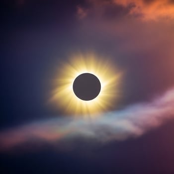 Radiant Solar Corona During a Total Eclipse, Framed by Moody Purple and Orange Clouds. photo