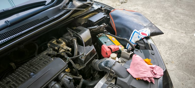 Car engine bay under maintenance with open hood at an auto repair shop. photo