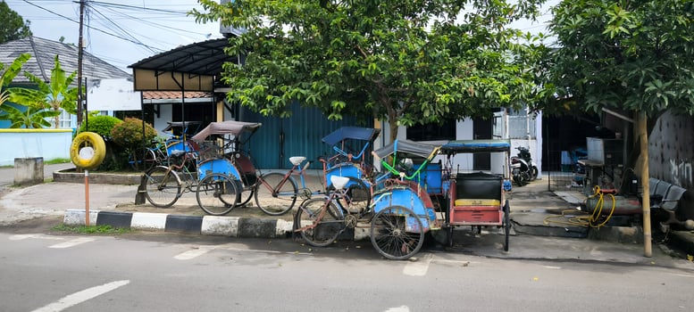Traditional Indonesian Becak Pedicabs Parked on a City Street photo
