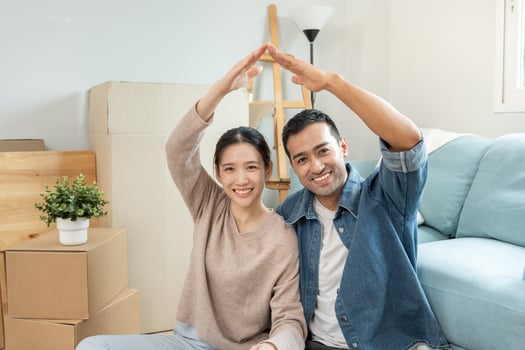 relocation., Couple show identify of home on new house, inside the room was a cardboard box contain personal belongings. move in the new apartment or condominium. photo