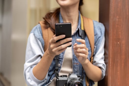 Young woman photographer using smartphone outdoors in urban setting photo