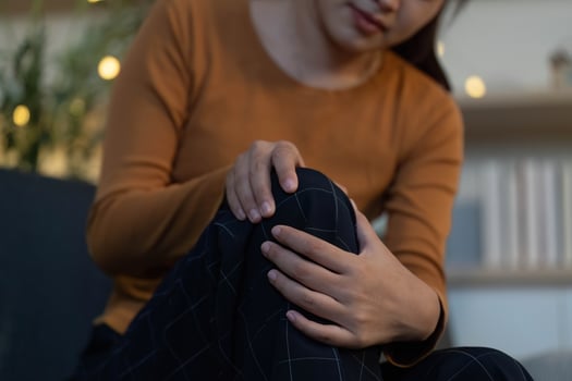 Health Awareness. Individual Experiencing Knee Pain at Home photo