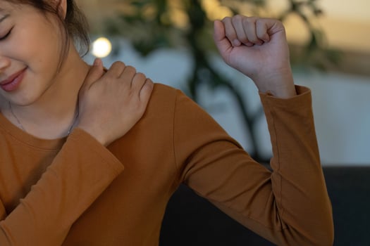 Health Awareness. Young woman experiencing shoulder discomfort at home. photo
