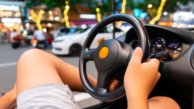 Close-up of hands on a steering wheel driving a car on a blurred city street at night. photo