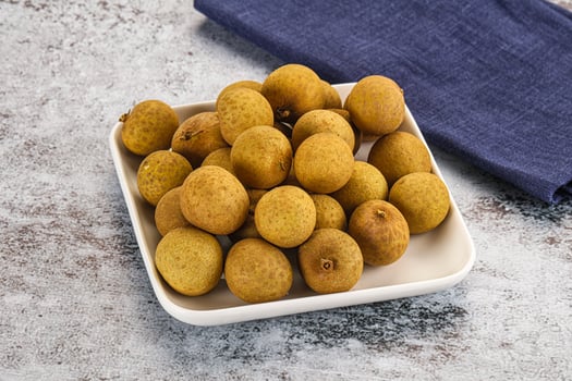 A white plate with a bowl of kiwi fruit photo