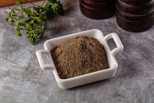 A small white bowl filled with brown powder photo