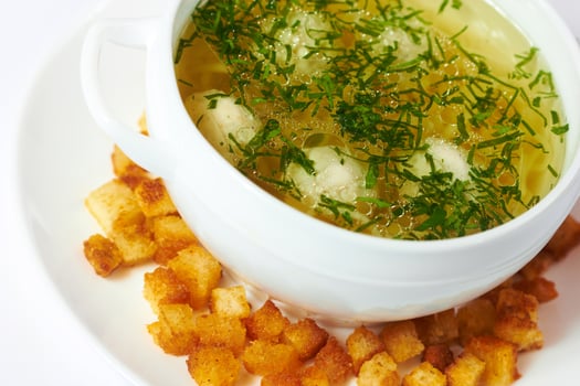 Soup with meatballs in a bowl and crackers photo