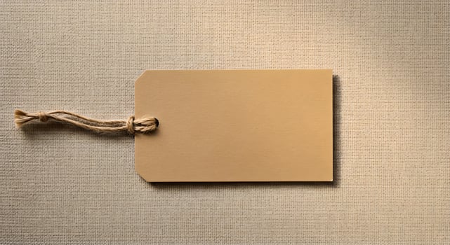 Blank kraft paper tag with jute rope on linen, ideal for natural branding and packaging. photo