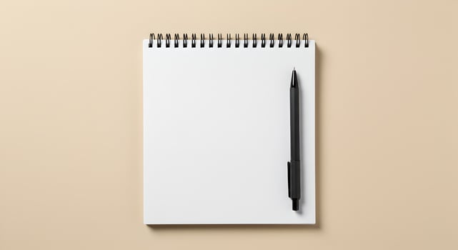 Top-Down White Spiral Notebook with Black Pen on Beige Background. photo