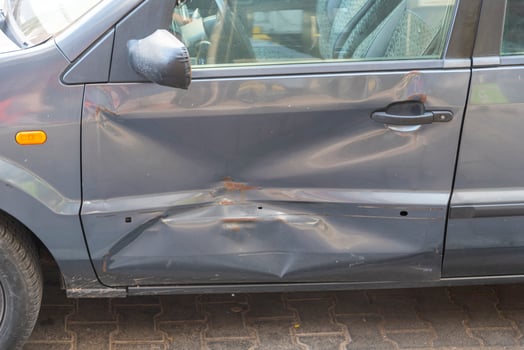 Damage to vehicle side door in busy urban area during daytime following a minor accident incident photo