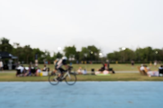 Defocus background of outdoor public park with people a rest and ride a bike photo