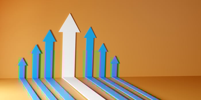 Growth in business and leadership represented by a white arrow standing out among upward blue arrows on orange background. A symbol of success, performance, and continuous progress. photo