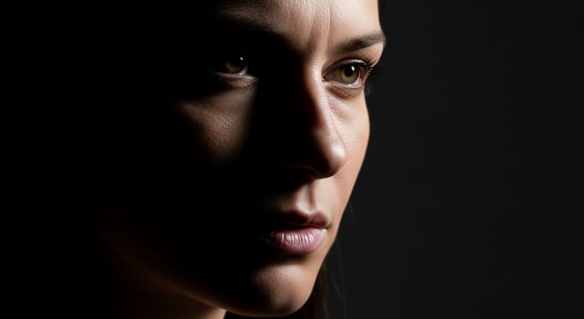 A woman with dark hair and a dark background photo