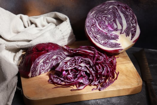 Shredded purple cabbage on wooden cutting board. photo