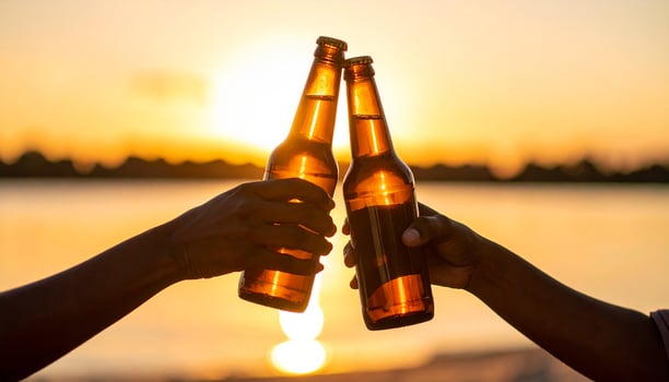 Golden Hour Toast Silhouetted Hands Clinking Beer Bottles Against a Radiant Sunset photo