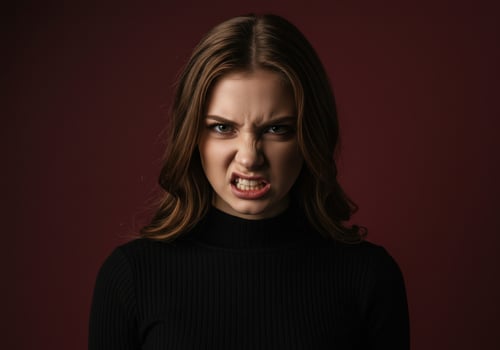 Portrait of a furious young woman with an angry face snarling and showing her white teeth photo