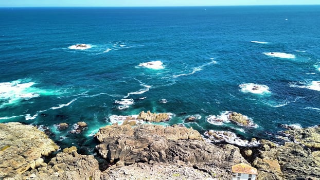 Experience the Breathtaking Coastal Views, Featuring Rocky Shores and the Tranquil Ocean Waves photo