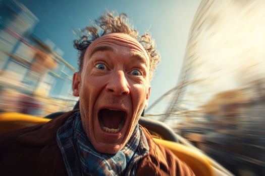 A man is on a roller coaster with his mouth open photo