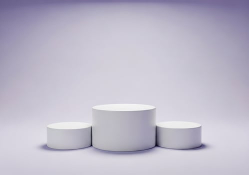Three white cylinders on a light purple surface photo