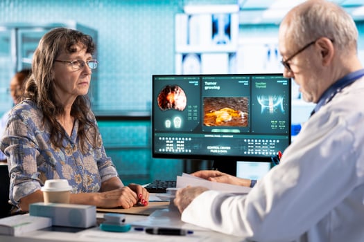 Senior general practitioner and ill patient examine the hospital records during check up visit, doing a scan interpretation of x ray results. Physician emphasizing healthcare services on insurance. photo