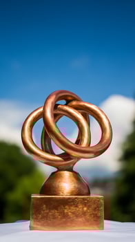 Shining Copper Sculpture Against a Bright Blue Sky. photo