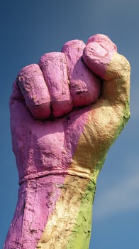 Colorful Fist Sculpture Reaching Up Against a Clear Blue Sky. photo
