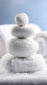 Serene White Stones Balanced on Soft Towels with Blurred Blue Background. photo