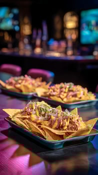 Loaded Nachos With Cheese and Toppings on a Table with Bar Lights. photo