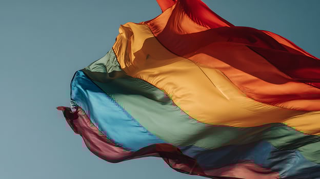 Rainbow Flag Billowing Freely Against a Clear Blue Sky. photo