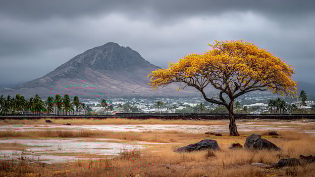 Golden tree stands tall against dramatic mountain and cloudy sky. photo