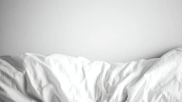 Soft White Blanket Gently Draped Against a Bright White Background. photo