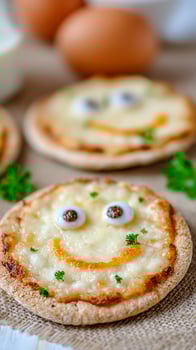 Fun Mini Pizzas Decorated Like Smiley Faces with Melted Cheese and Parsley. photo
