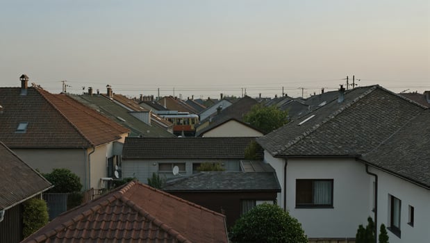 A serene cityscape presents an aerial view of residential houses with red tile roofing. captured a tranquil scene with focus on details of architecture. photo