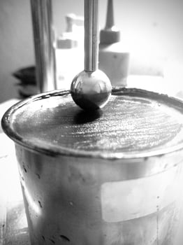 Close up photo of Ball penetration test on asphalt to measure the resilience of asphalt mixtures with additives.