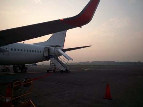 A commercial plane lands at dusk on an airport apron. photo