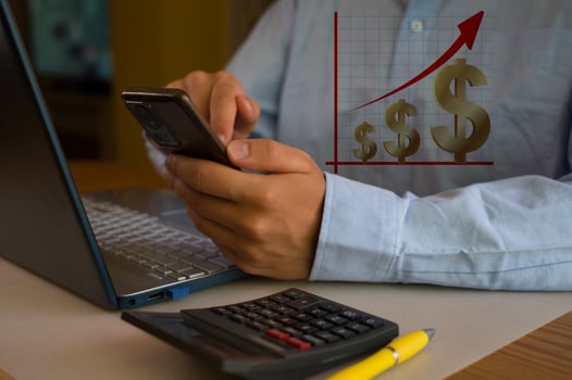 A man is using his cell phone to check his finances photo